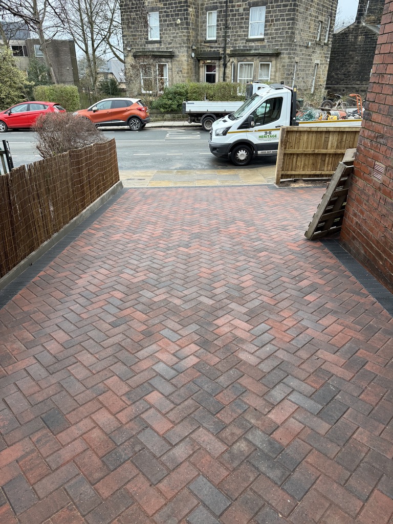 Red herringbone block paving with a charcoal border