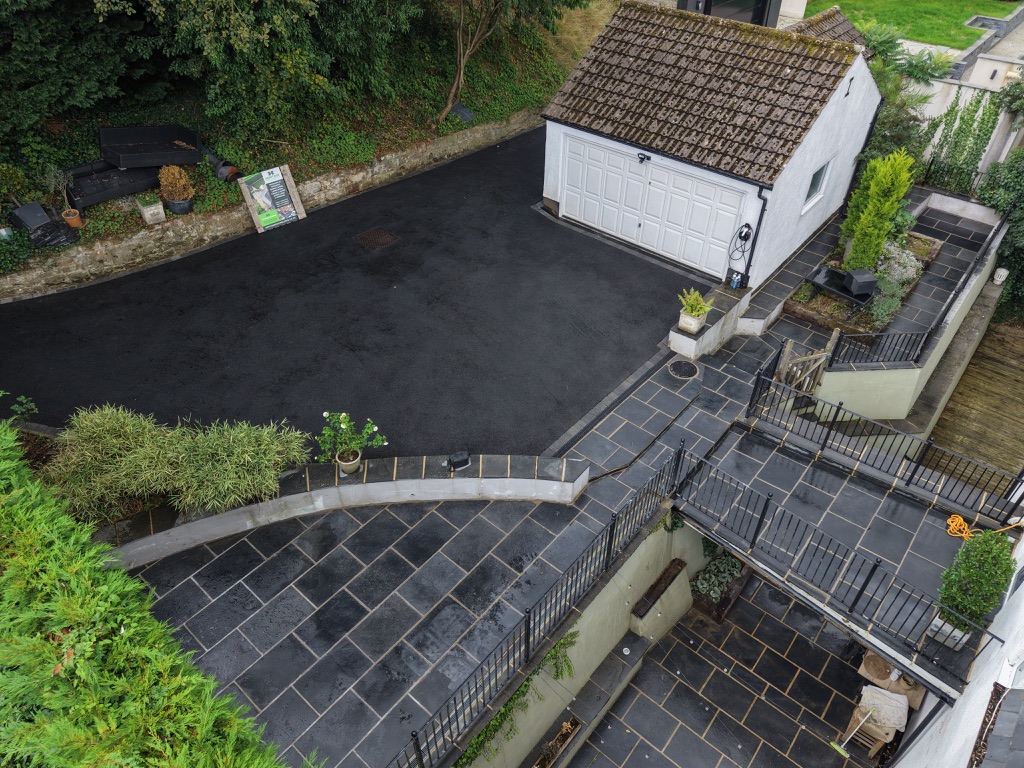 Aerial view of a completed tarmac driveway with block-paved borders and a detached garage