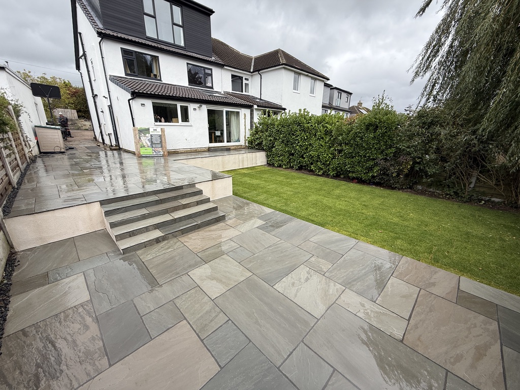 Finished Kandla Grey sandstone patio and steps with rendered retaining walls and new turf in Horsforth