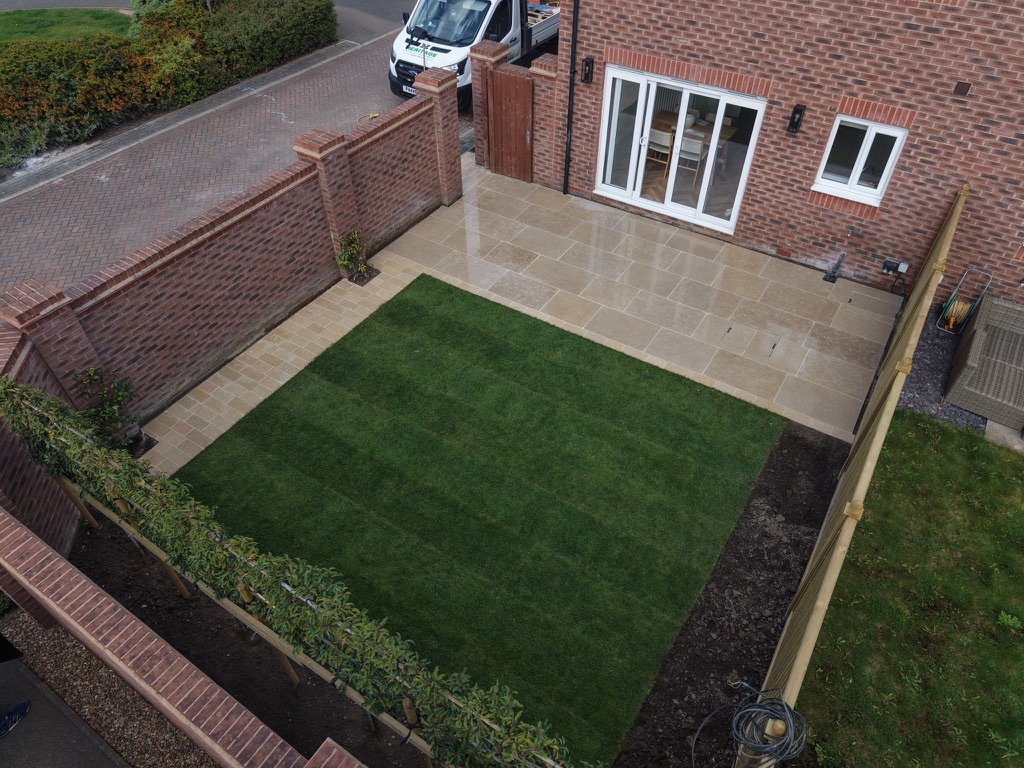 Completed Egyptian limestone terrace beside the house and around the lawn in Wakefield