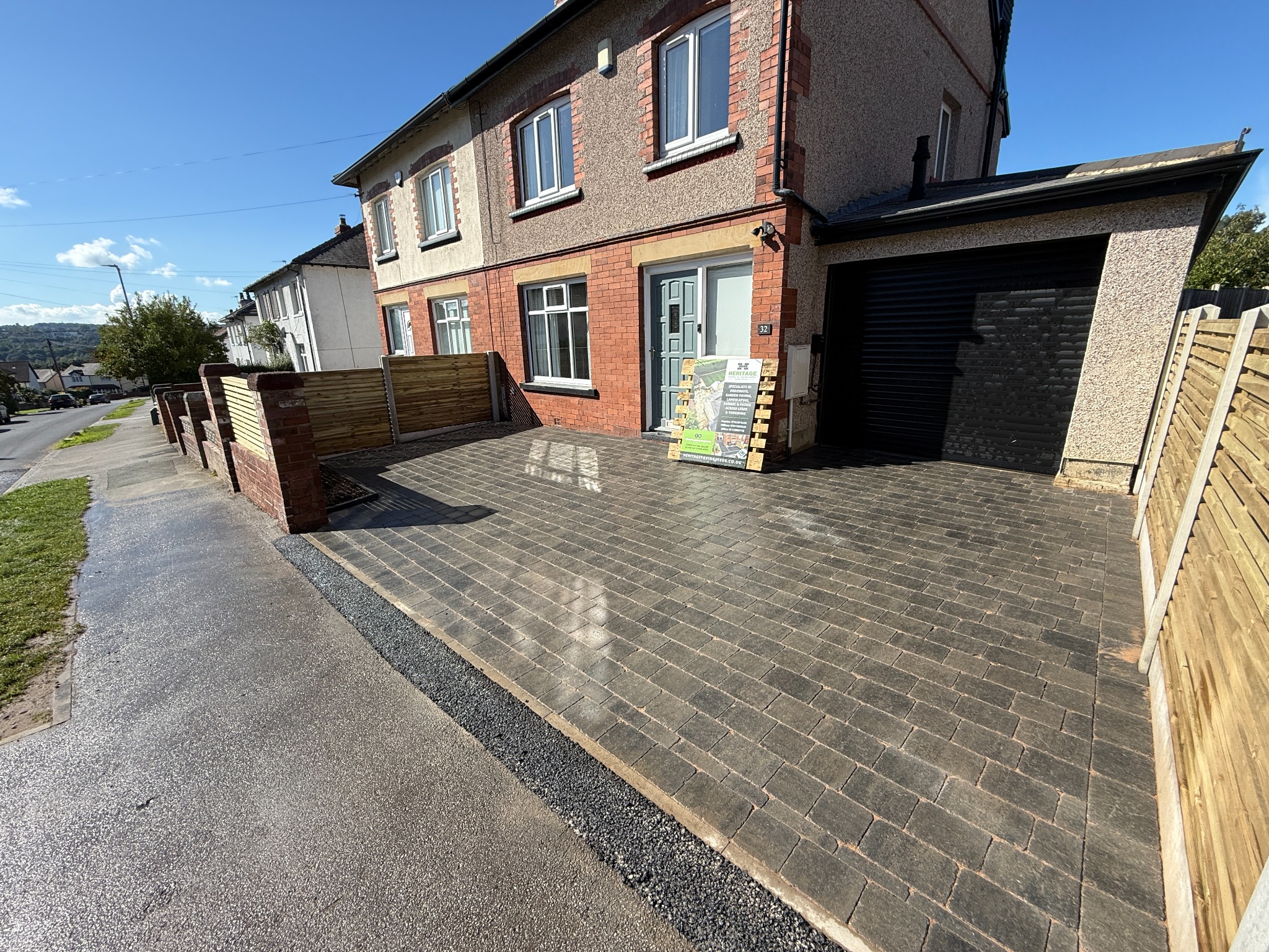 Grey block-paved driveway beside a house, garage and bespoke timber fencing in Leeds