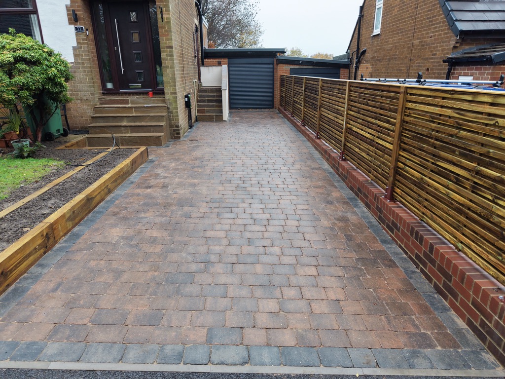 Tumbled block paving driveway with contrasting edging, entrance steps and horizontal timber fencing by Heritage Paving