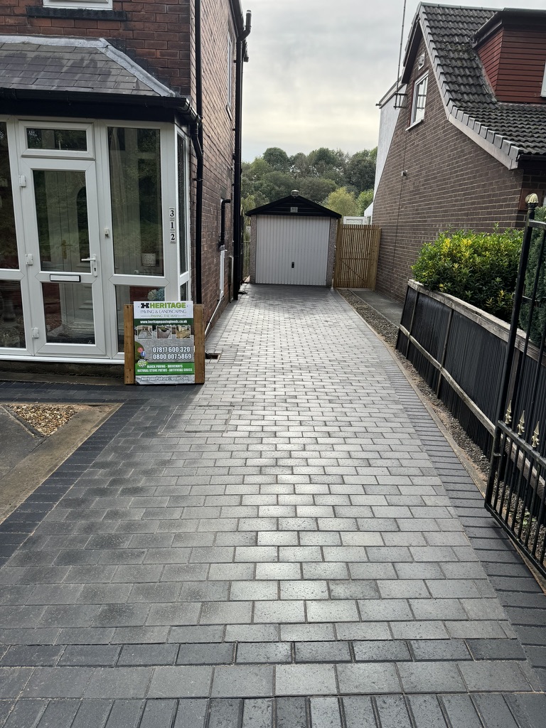 Grey block paving leading to a garage