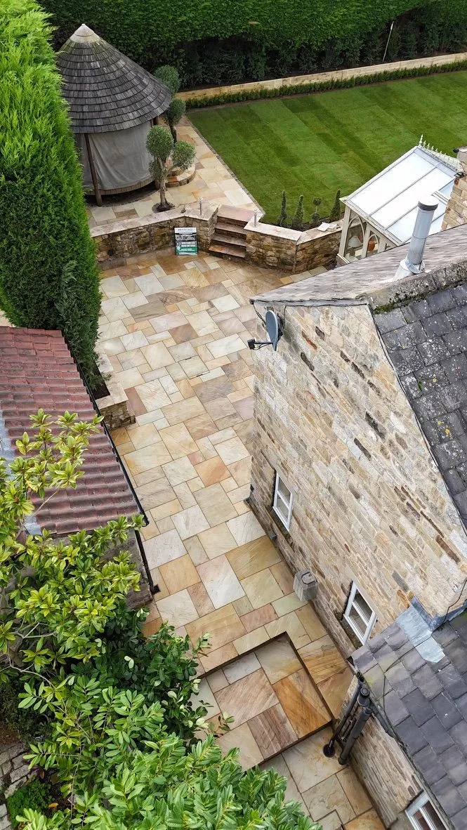 Portrait aerial view showing Fossil Mint sandstone paths, patio areas and newly laid turf in Linton