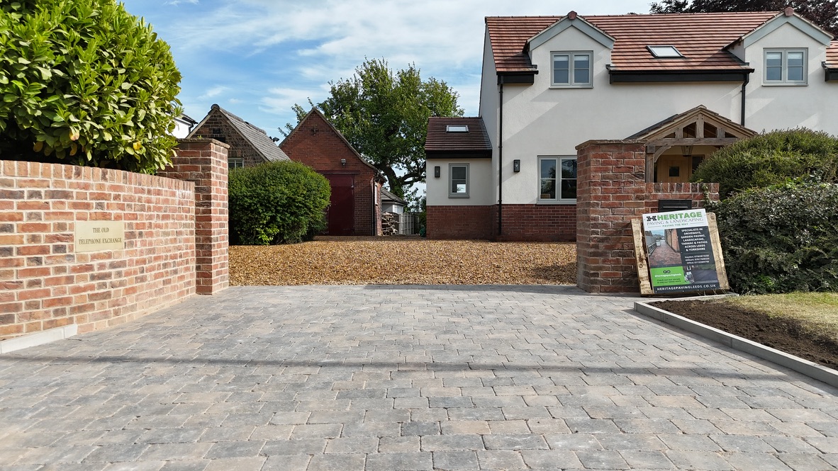 Block-paved driveway and entrance between brick pillars, installed by Heritage