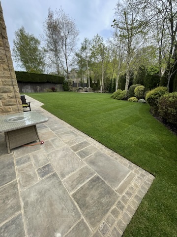 Relaid Indian sandstone patio and cobbled edging beside the lawn — Wigton Lane, Leeds